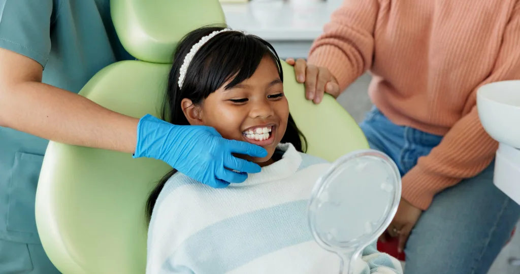 Pediatric dentist performing dental exam on child